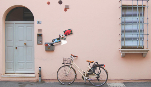 Bicycle outside a house with a full mailbox